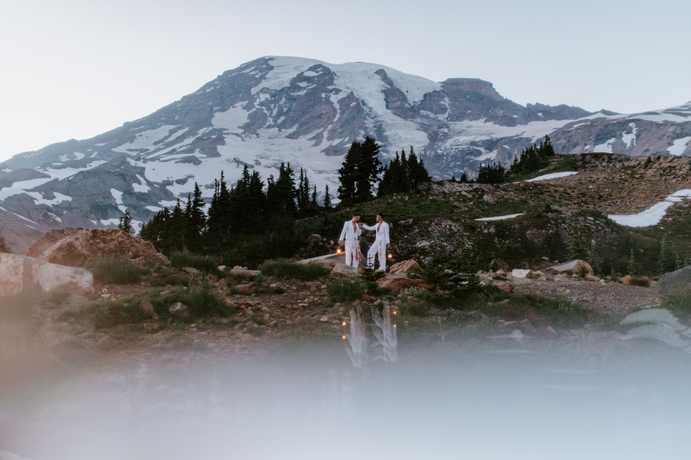 Fred and Brooks walking with lanterns after their elopement in Mount Rainier.