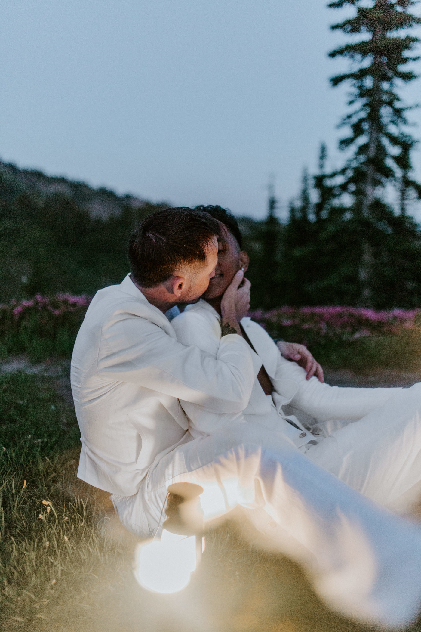Brooks and Fred sit next to a latnern on the grass at Mount Rainier.