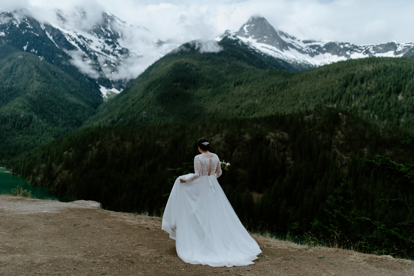 Elizabeth walks along the cliffside of Diablo Lake Overlook. Elopement photography at North Cascades National Park by Sienna Plus Josh.