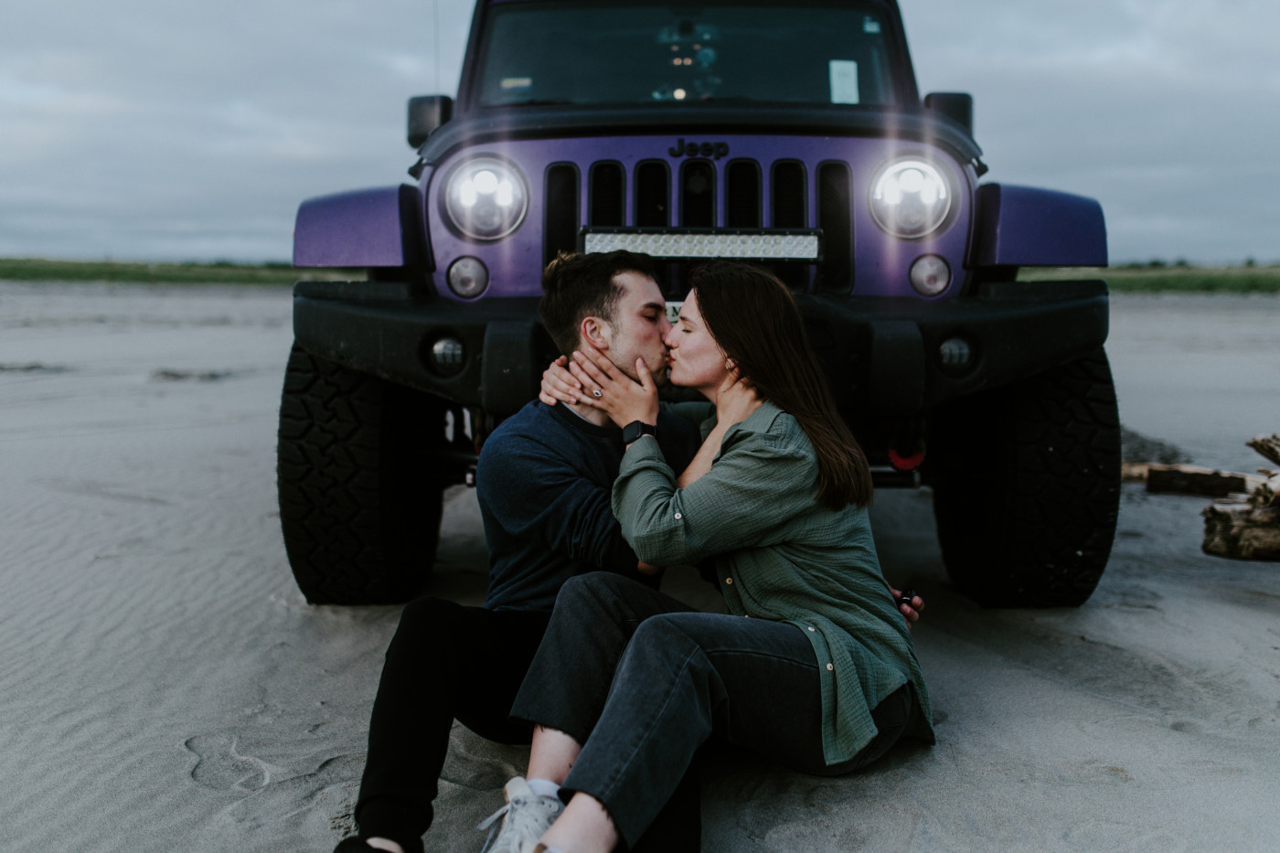 Taylor and Kyle sit on the sand, kissing. Elopement photography at North Cascades National Park by Sienna Plus Josh.