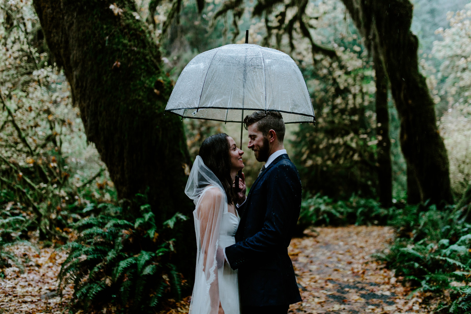 Mollie and Corey share an umbrella. Elopement photography in the Olympic National Park by Sienna Plus Josh.