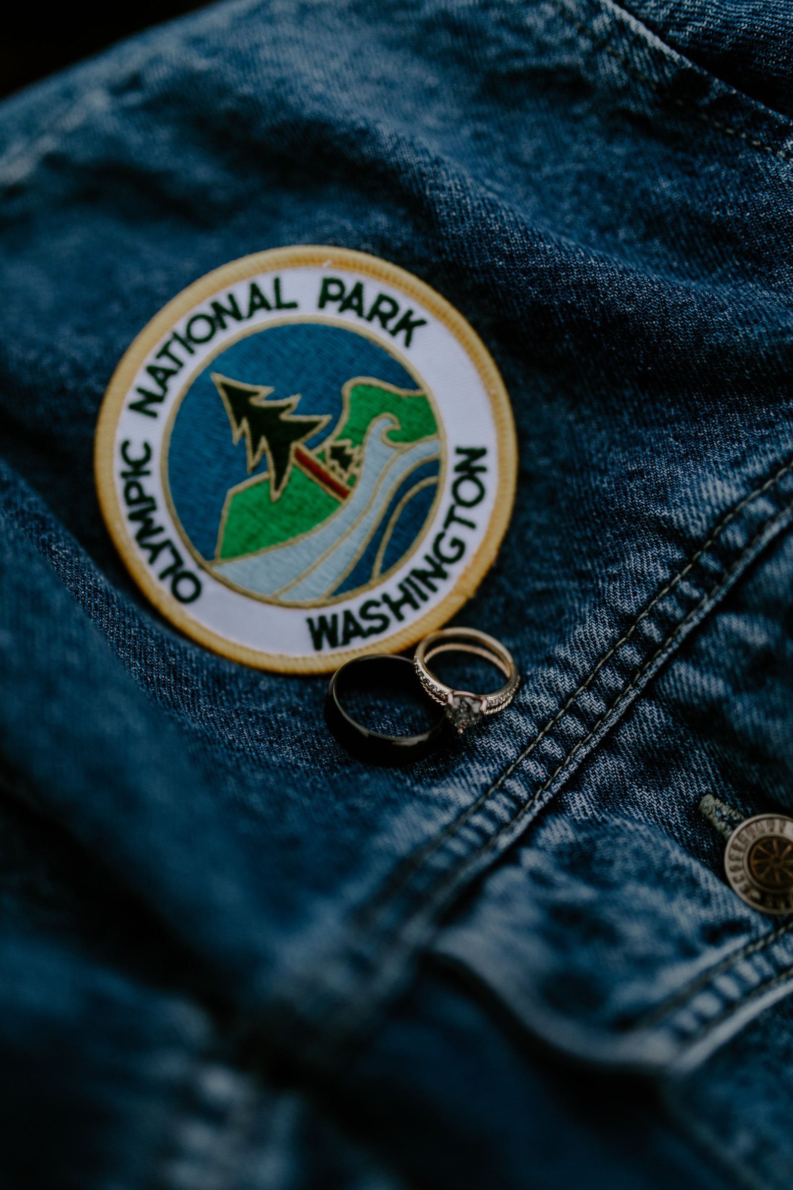 Corey and Mollie's rings sit on next to a patch. Elopement photography in the Olympic National Park by Sienna Plus Josh.