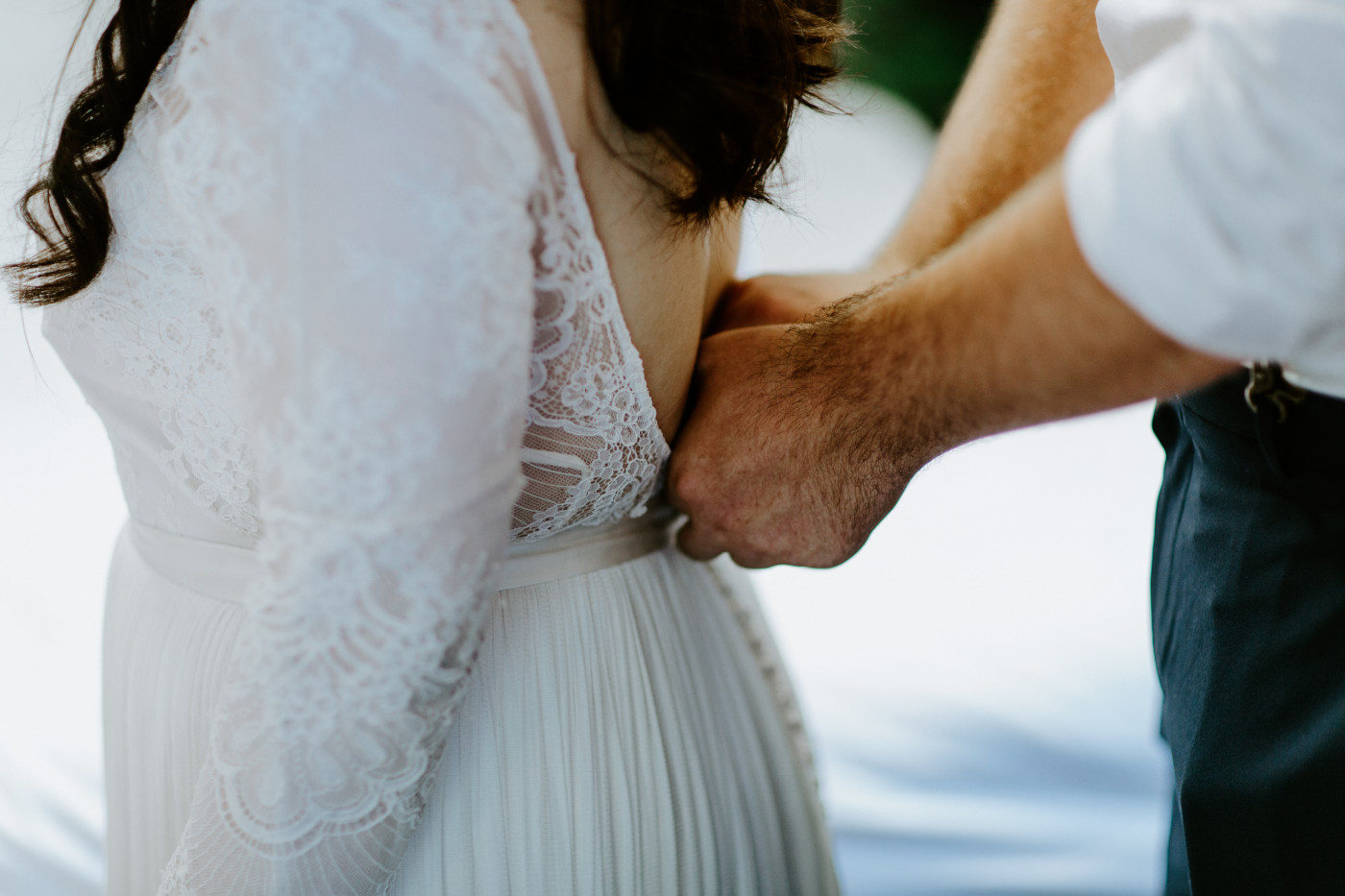 Brooke gets help from Jack with zipping up her dress. Elopement photography at Olympic National Park by Sienna Plus Josh.