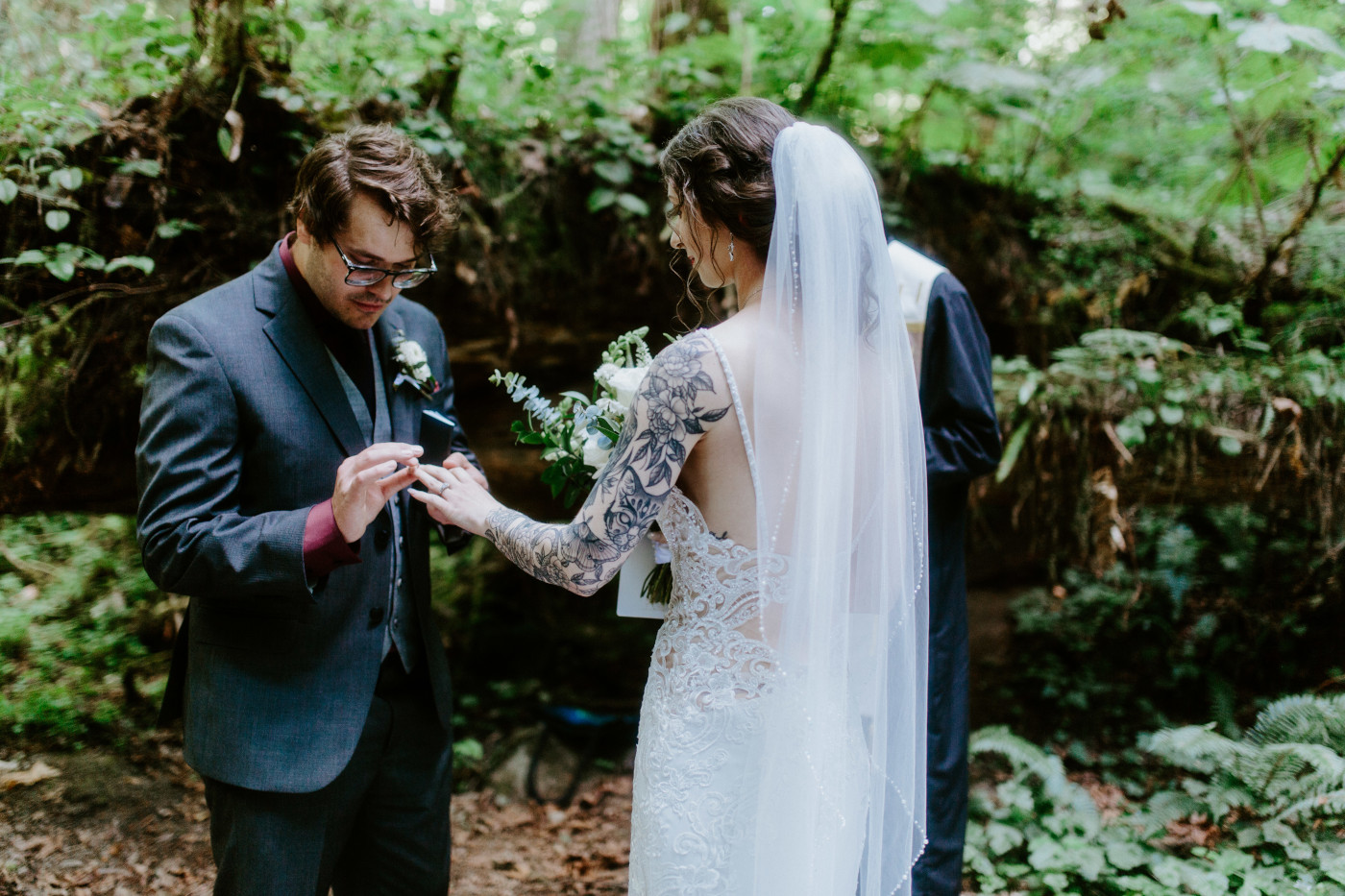 The groom puts a ring on the finger of his bride during their elopement ceremony in Olympic National Park.