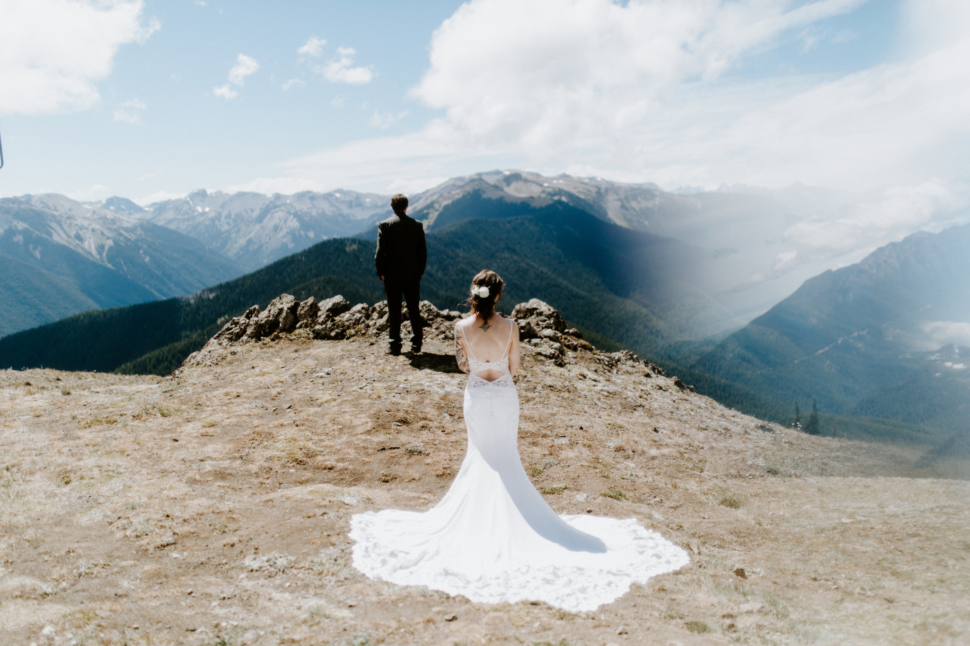Adrielle stands with her dress laid out at Olympic National Park.