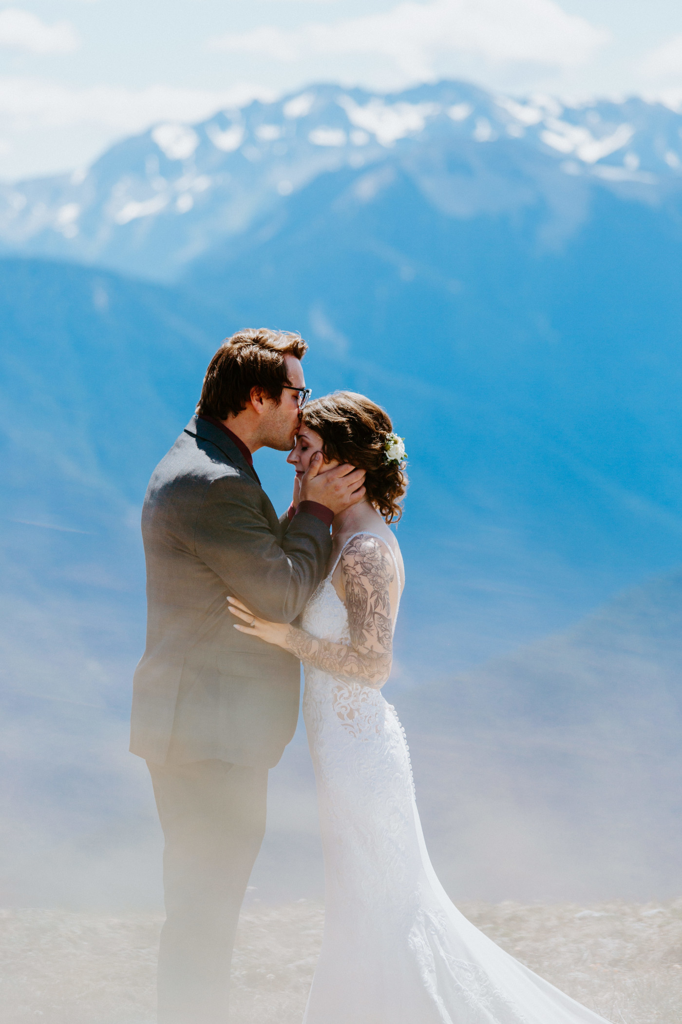 The groom kisses the bride on the forehead at Olympic National Park.