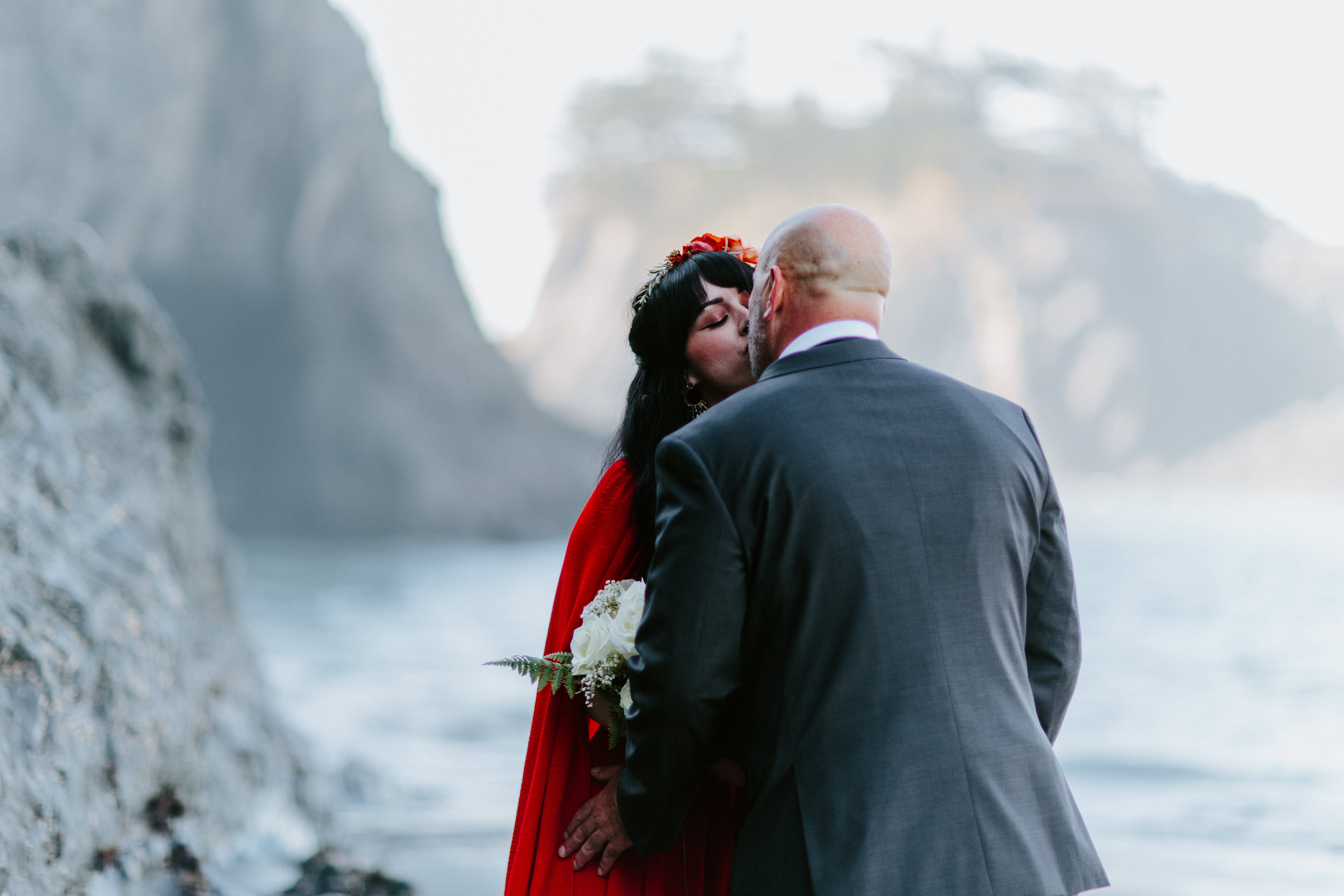 Rachael and Boyd kiss while standing on the beach of before their elopement at Samuel H. Boardman, Oregon.