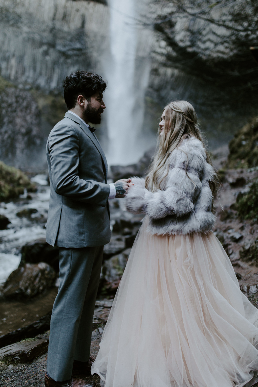 Tyanna and Boris stand in front of Latourell Falls, OR. Adventure elopement in the Columbia River Gorge by Sienna Plus Josh.