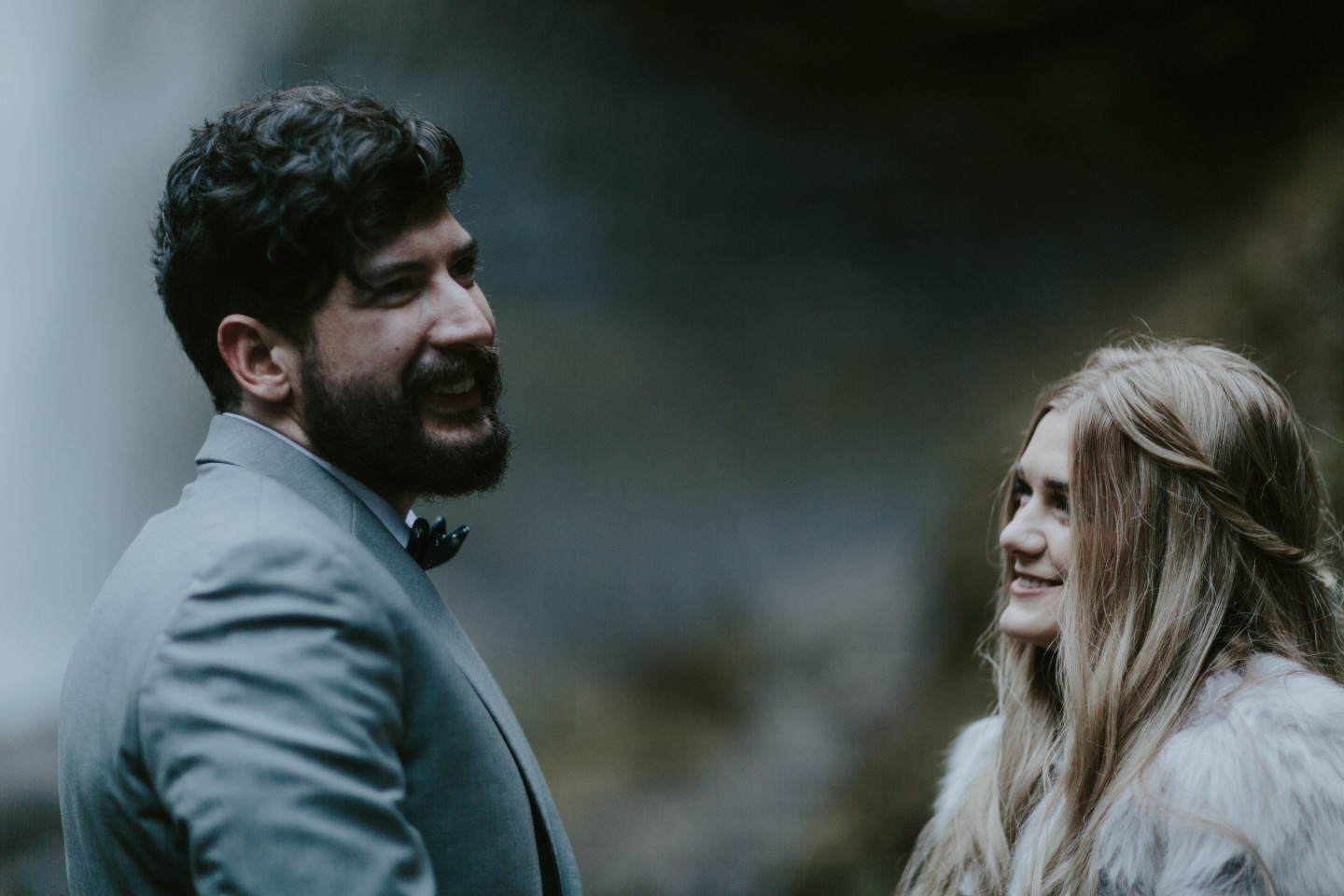 Boris looks toward their officiant at Latourell Falls, OR. Adventure elopement in the Columbia River Gorge by Sienna Plus Josh.