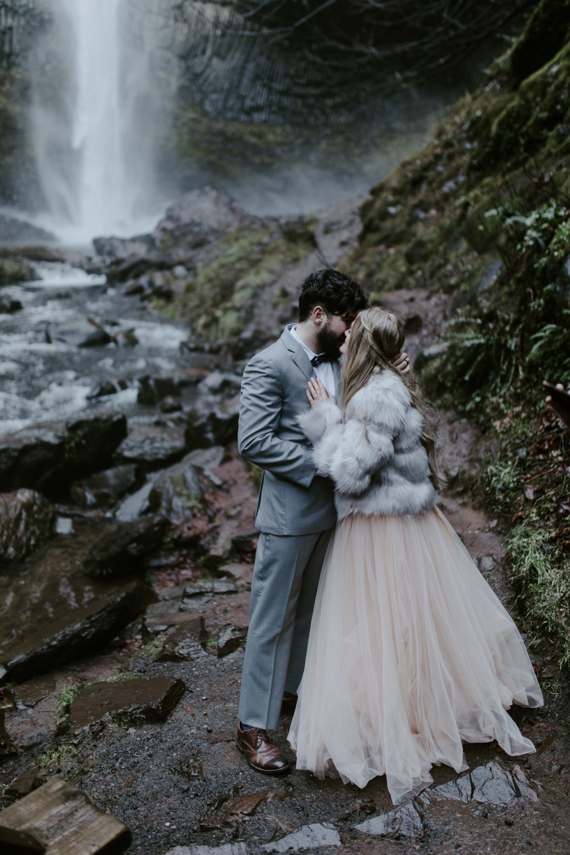 Boris whispers to Tyanna in Latourell Falls, OR. Adventure elopement in the Columbia River Gorge by Sienna Plus Josh.