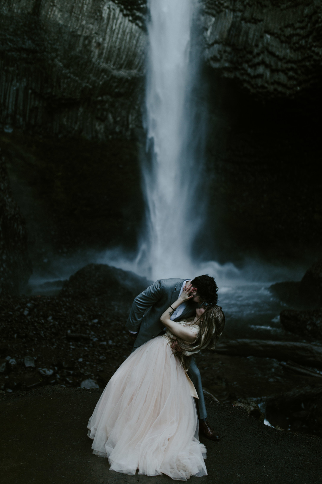 Boris dips Tyanna before they kiss in front of Latourell Falls, OR. Adventure elopement in the Columbia River Gorge by Sienna Plus Josh.