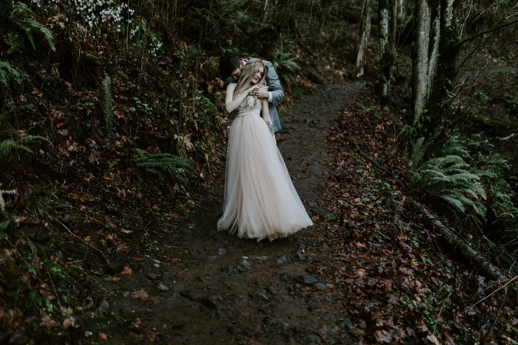Boris holds Tyanna along the trail at Latourell Falls. Adventure elopement in the Columbia River Gorge by Sienna Plus Josh.