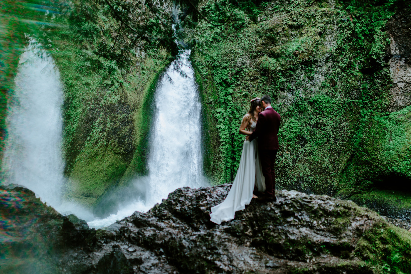 Jordan and Andrew stand in front of each other at Wahcella Falls.